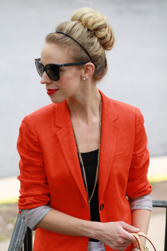 sock bun, black cateye Chanel sunglasses, red orange blazer, gold tassel necklace, black tank