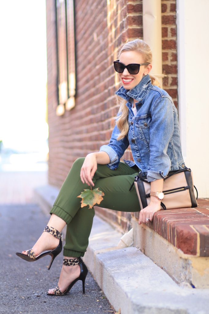 J. Crew distressed denim cropped jacket, cuffed sleeves, popped collar on denim jacket, olive track pants, tapered track pants, leopard ankle strap heels, Kate Spade colorblock bag, Chanel cateye sunglasses, fall outfit