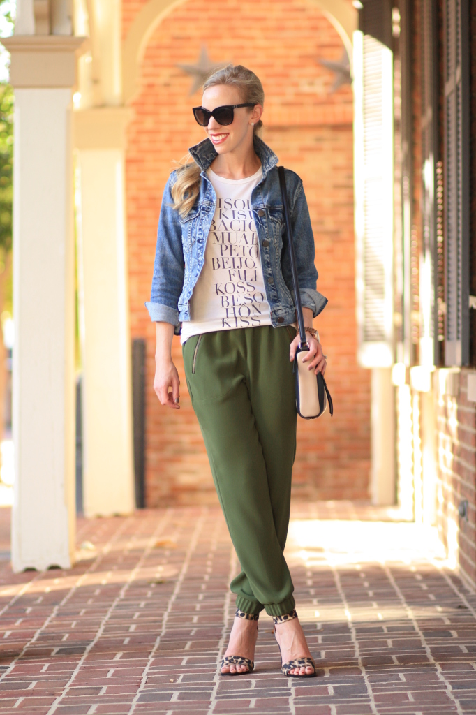 J. Crew distressed denim cropped jacket, graphic tee kisses, olive J. Crew turner pant, tapered track pants with zippers, leopard print ankle strap heels, Kate Spade colorblock crossbody bag, tapered track pants with heels
