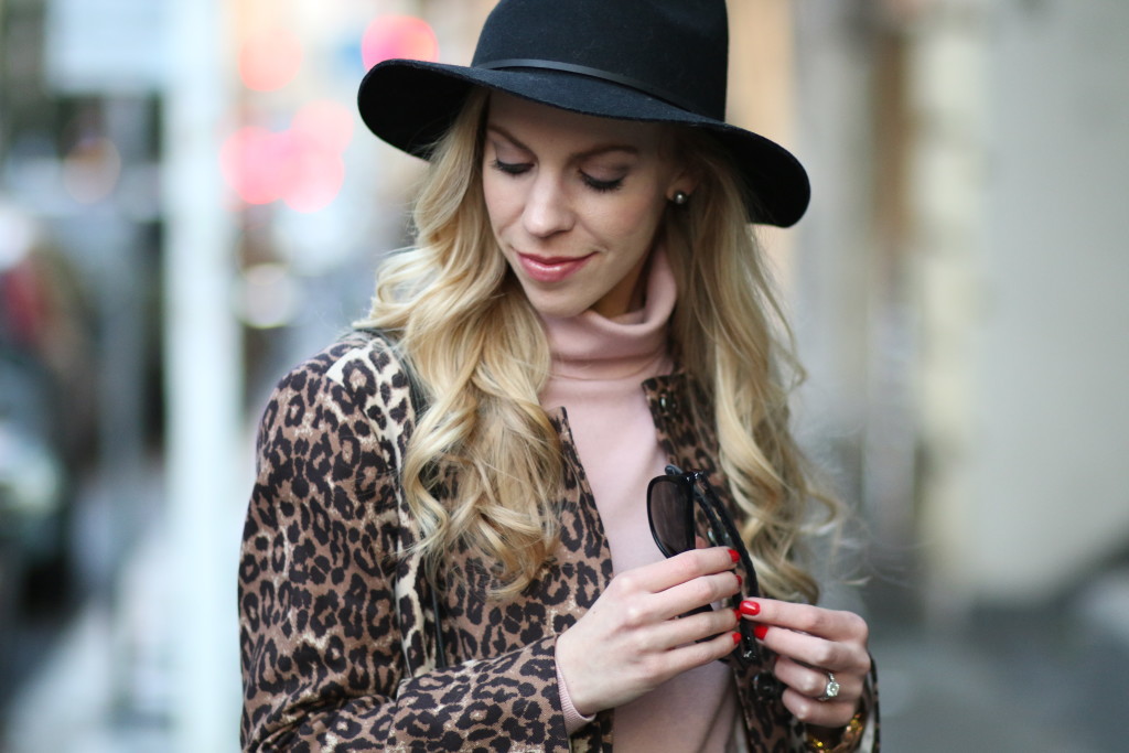 Brixton wesley black wool fedora hat, soft spring makeup, leopard coat with pink turtleneck, J. Crew merino mauve pink turtleneck, Chanel quilted leather trim sunglasses, blush pink and leopard outfit