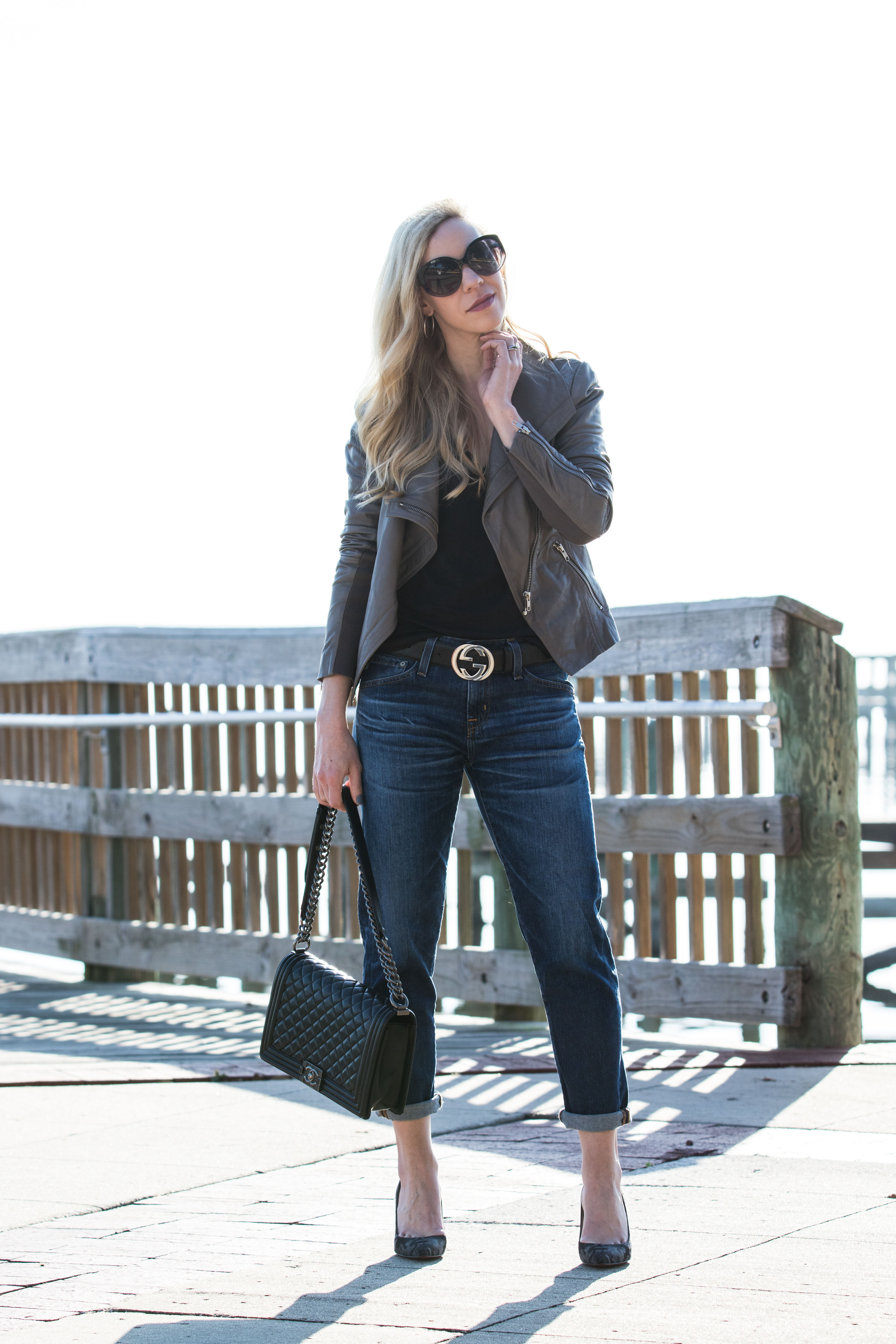 Meagan Brandon fashion blogger of Meagan's Moda wears Louis Vuitton black  shine shawl with black leather jacket, gray jeans and black moto boots for  chic black and gray outfit - Meagan's Moda