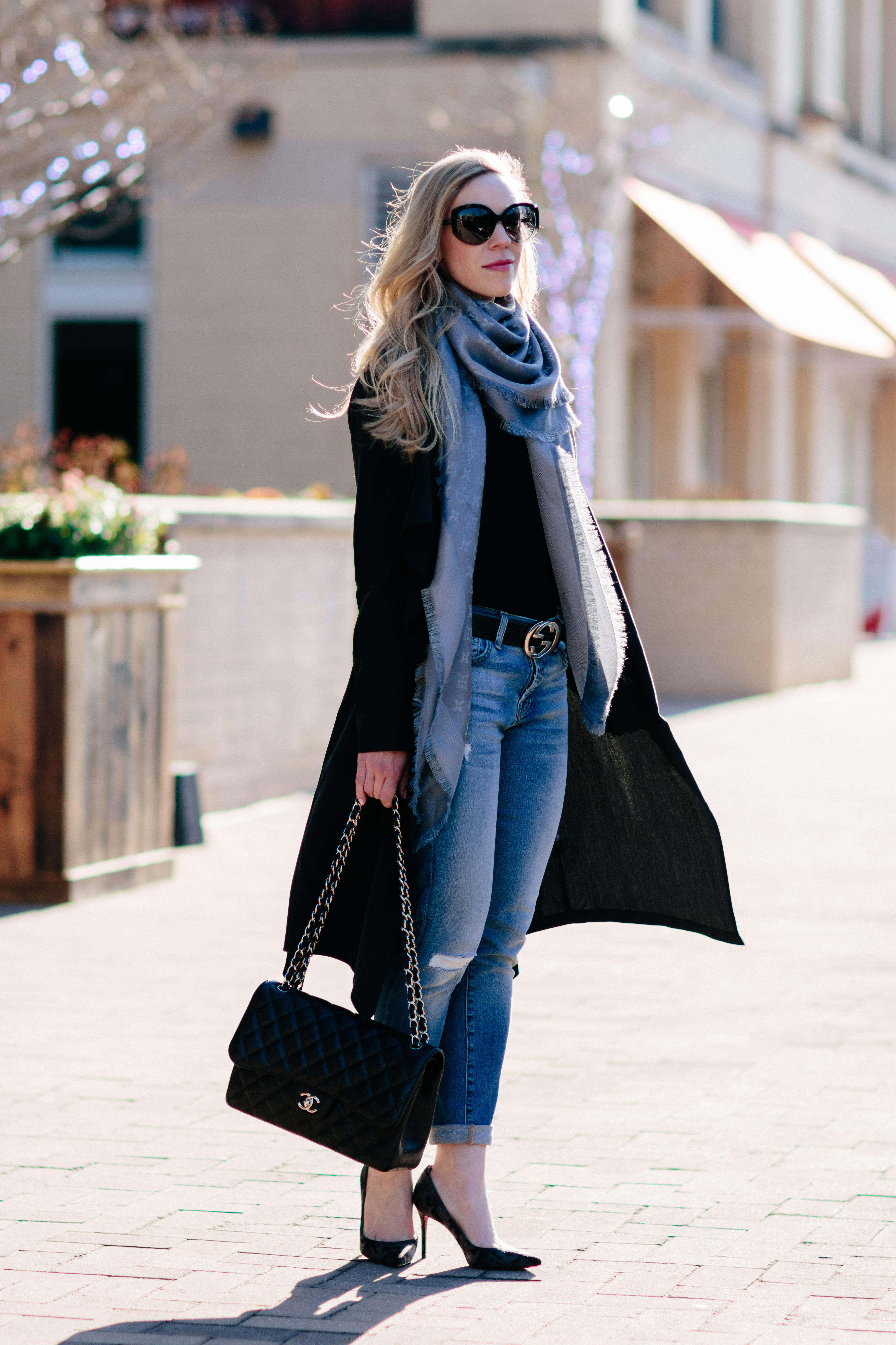 Woman with Louis Vuitton bag and Chanel scarf before Fendi fashion