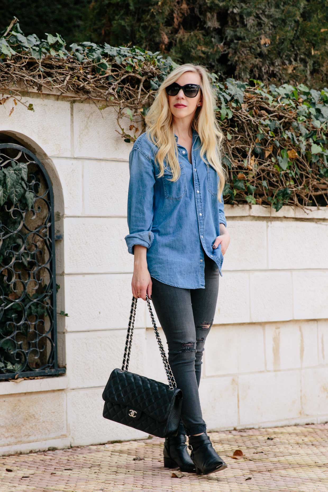 Meagan Brandon fashion blogger of Meagan's Moda wears oversized denim shirt  with black distressed jeans and black Chelsea boots, oversized denim shirt  outfit - Meagan's Moda