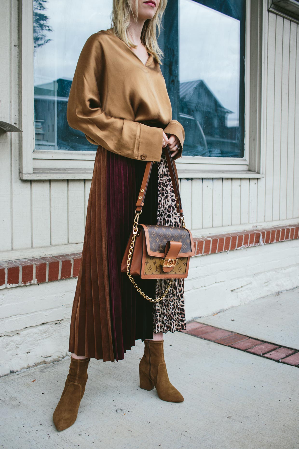 Meagan Brandon fashion blogger of Meagan's Moda wears H&M rust brown silk  shirt with leopard print pleated skirt, brown suede booties and Louis  Vuitton Dauphine bag for chic fall outfit - Meagan's